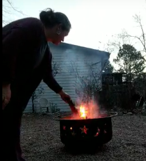 Woman tending a backyard fire pit